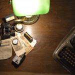 Tisch mit Lampe und vielen kleinen Gegenständen von der Taschenuhr bis zum Geldschein.