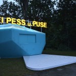 Blauer Pavillon mit neongelber Schrift: Bei Pess u. Puse
