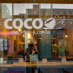 Fensterscheibe des Café Coco mit Schriftzug.