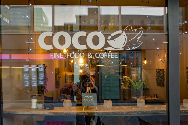 Fensterscheibe des Café Coco mit Schriftzug.