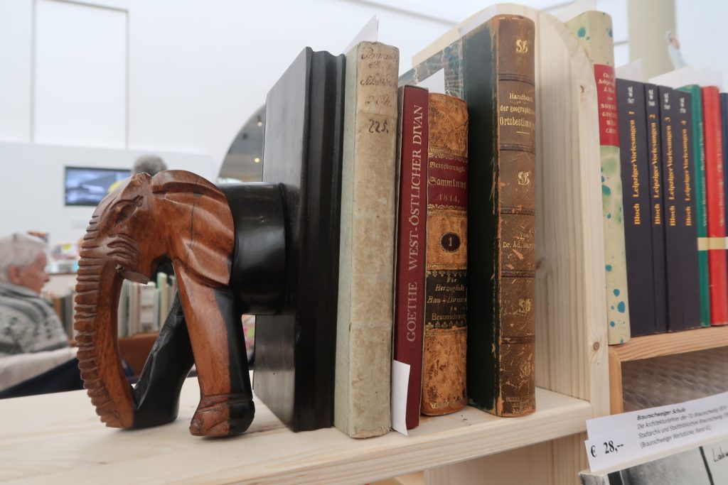 Buchstütze in Form eines halben Elefanten stützt alte Bücher.