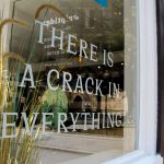 Ein Schaufenster mit der Aufschrift "There is a crack in everything"