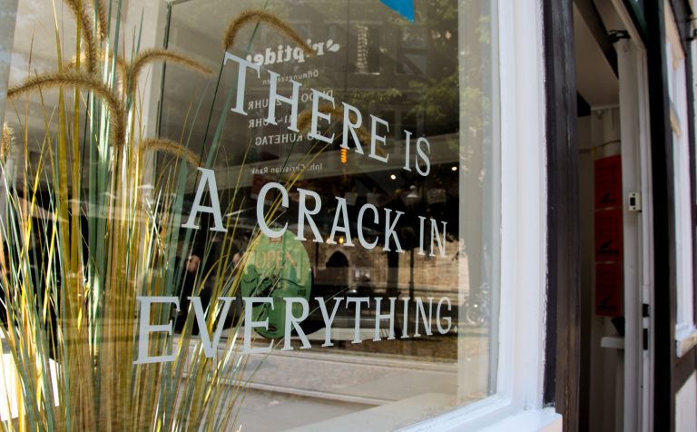 Ein Schaufenster mit der Aufschrift "There is a crack in everything"