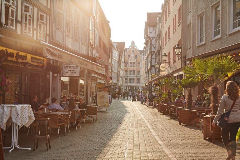 Straßenzug mit Cafés an beiden Seiten.