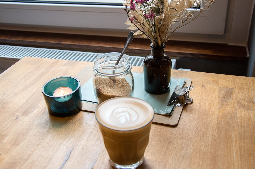 Glas mit Kaffee und Tischdeko auf einem Tisch