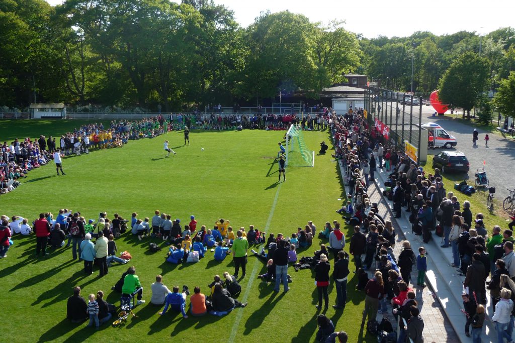 Fußballfeld mit vielen Zuschauer:innen
