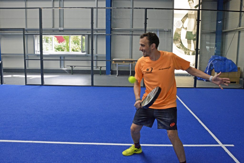 Ein Trainer spielt Padel-Tennis in der Halle.
