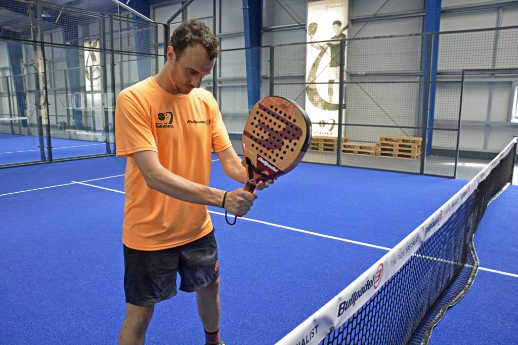 Ein Trainer zeigt, wie man einen Padel-Tennis-Schläger hält.