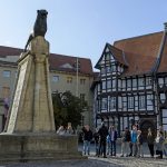 Der Burglöwe in Braunschweig mit einer Gruppe Menschen davor